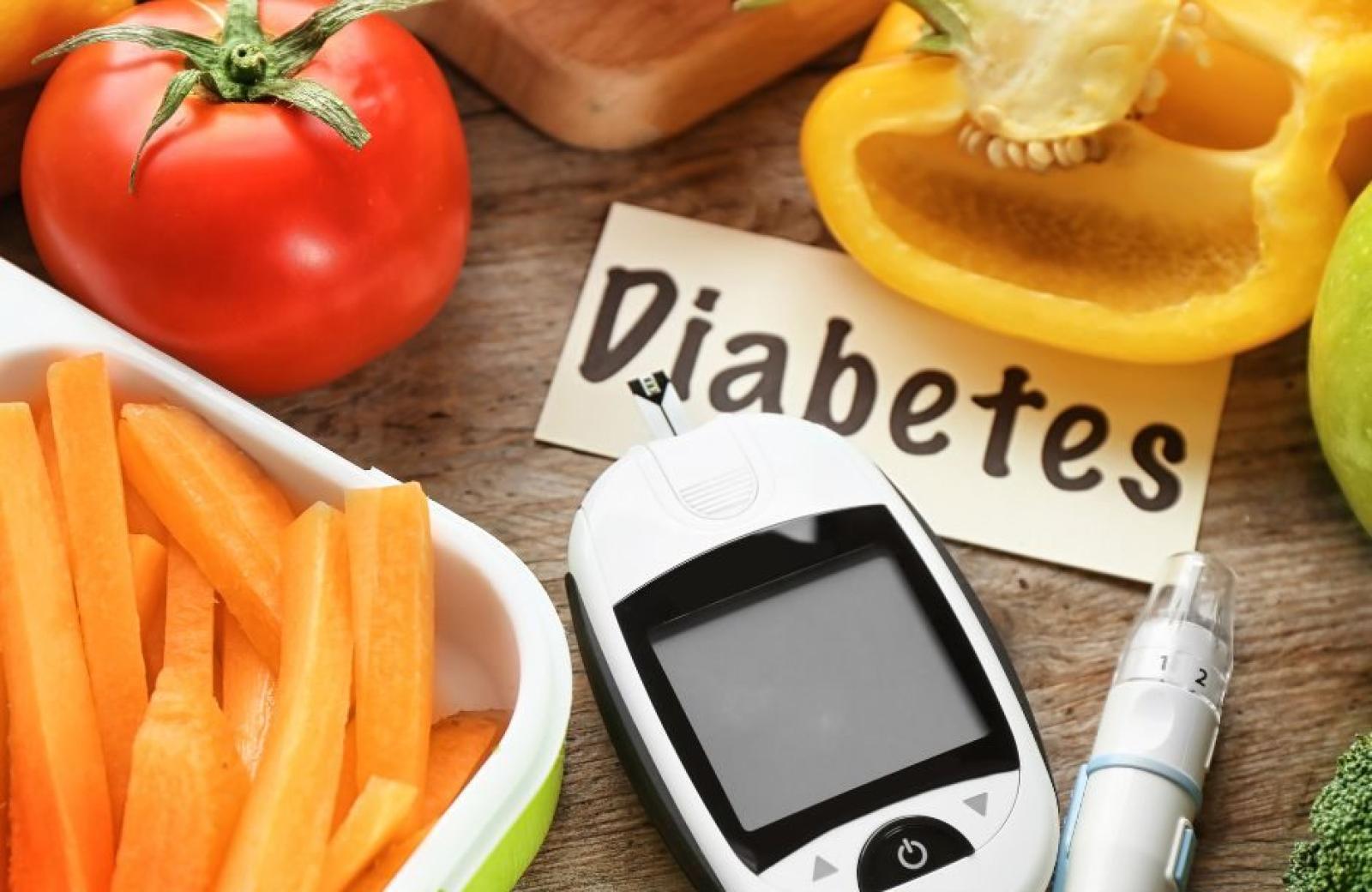 Blood glucose meter with diabetes sign, insulin pen and fresh vegetables