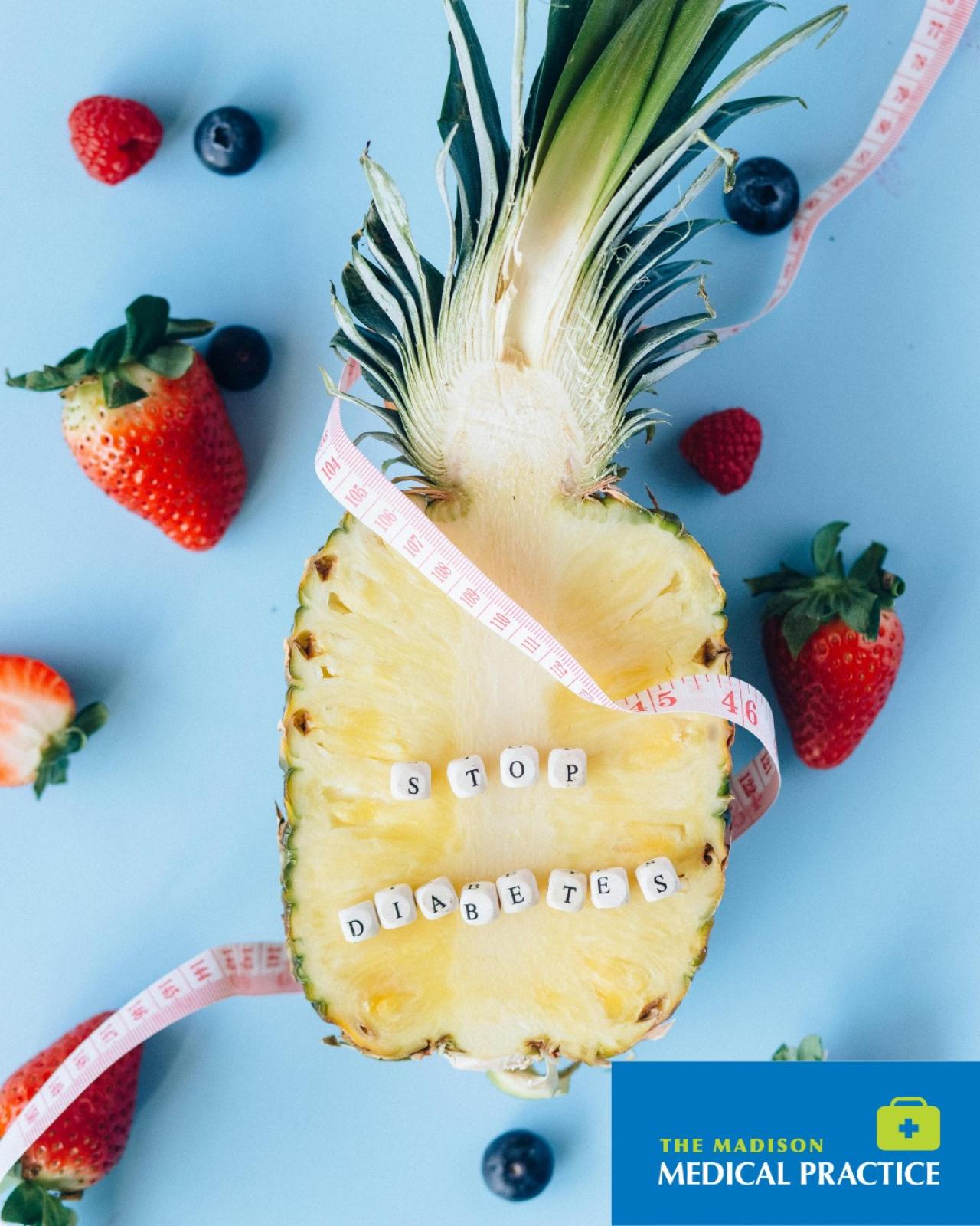 Half pineapple with ‘stop diabetes’ beads, surrounded by strawberries and blueberries