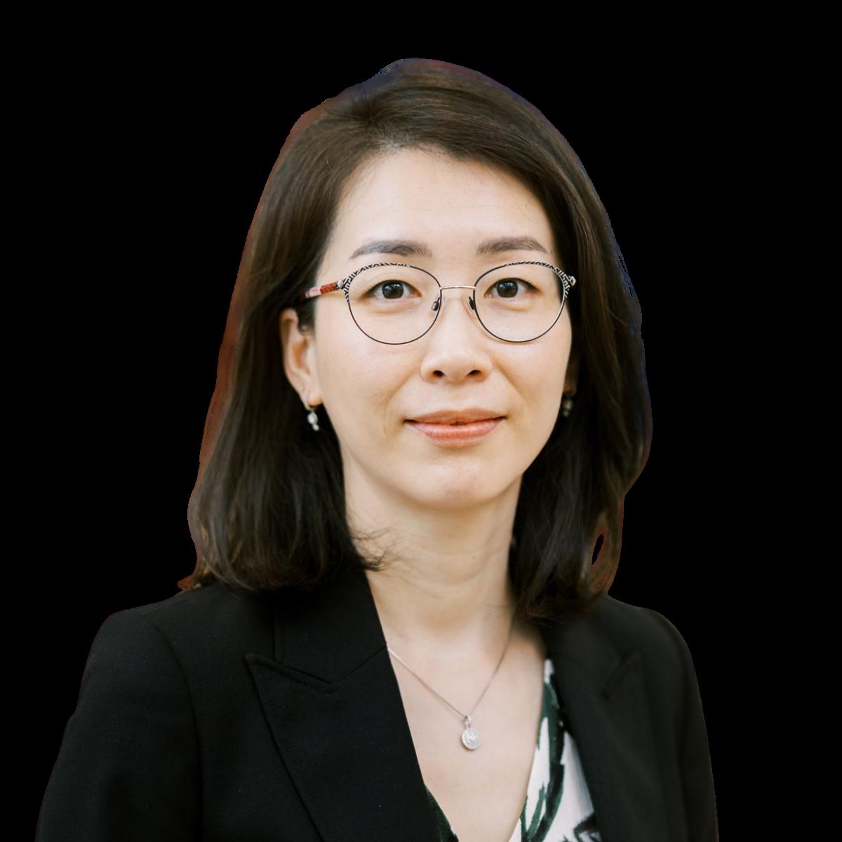 Professional headshot of a female doctor in glasses wearing a black blazer