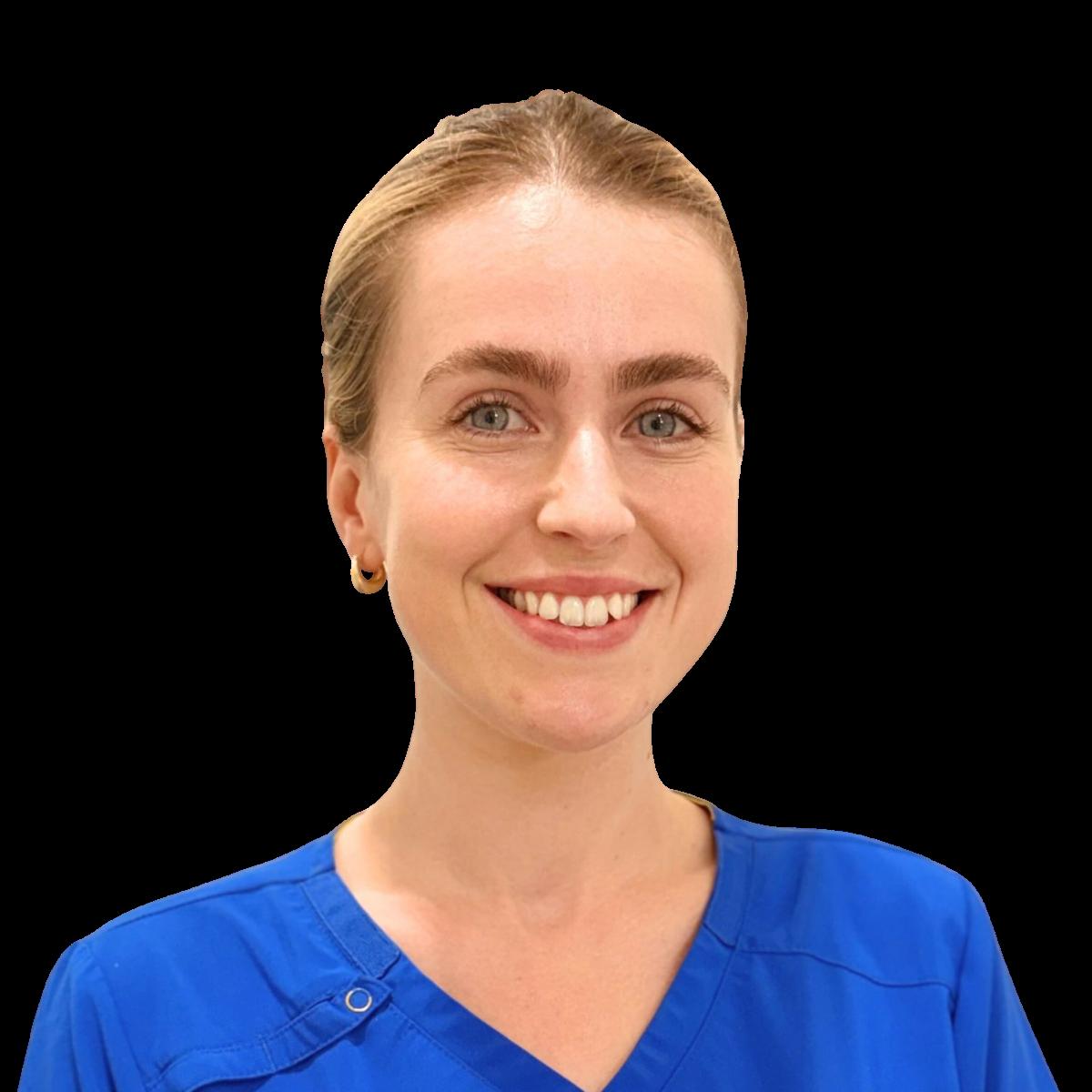 Female healthcare professional in blue scrubs smiling in a studio headshot