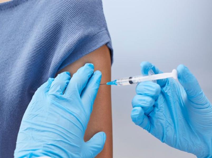 Healthcare worker administering a vaccine injection into an upper arm