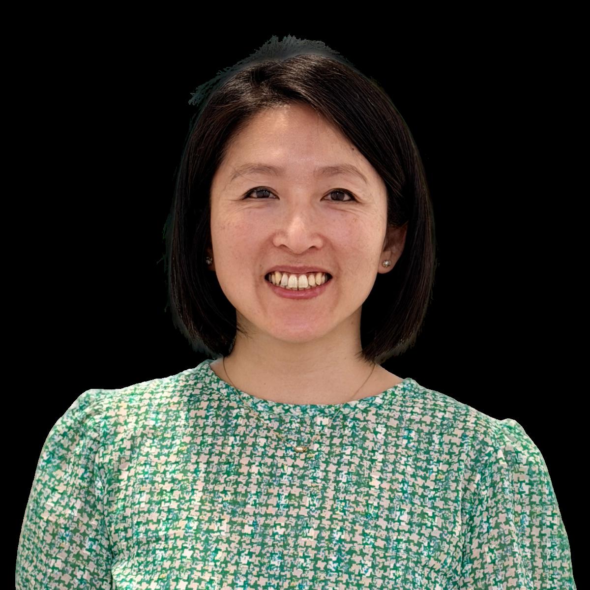 Professional headshot of a smiling female doctor in a green patterned blouse