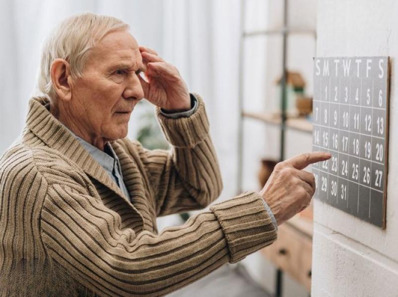 Older man checking an eye chart during a vision assessment
